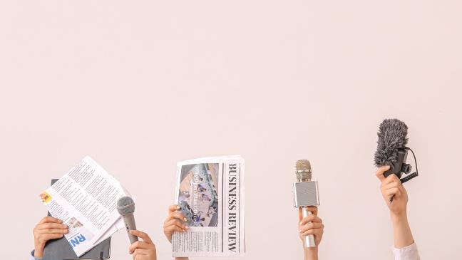 Eine Gruppe von Personen hält Mikrofone und Zeitungen, um ihre Ideen und Meinungen auszudrücken. (Link zur Seite Pressemitteilungen)