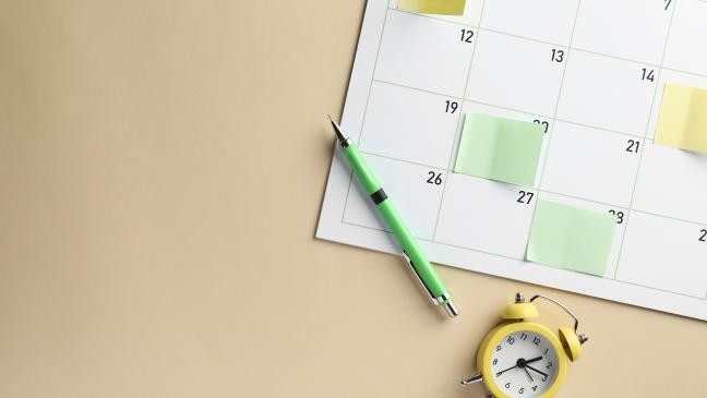 Kalender mit einem Stift und einem Wecker, der die Zeit für wichtige Termine anzeigt. (Link zur Seite Veranstaltungen)