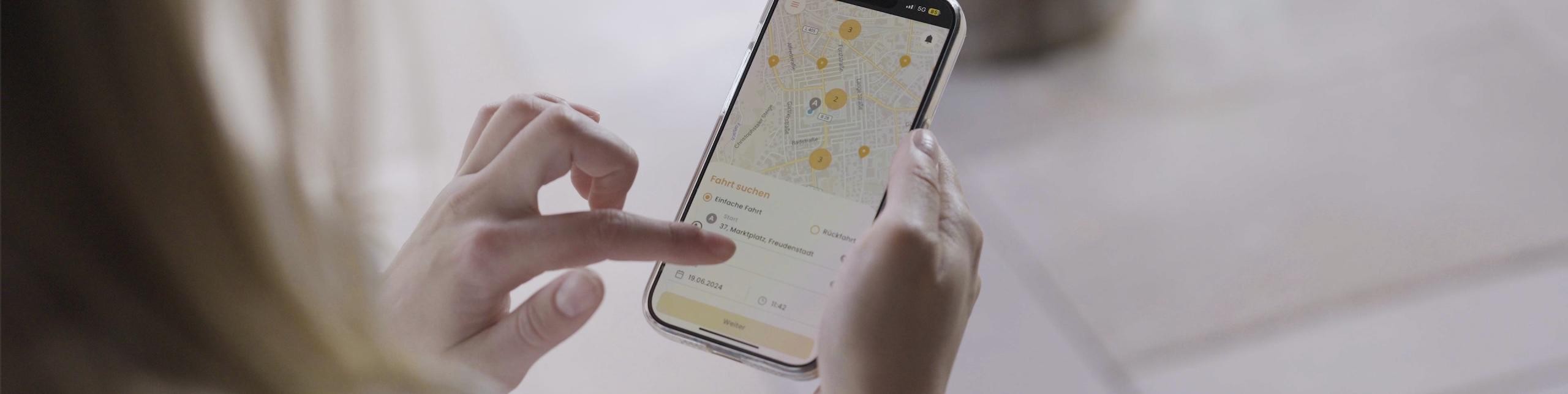 Eine Frau schaut auf ihrem Smartphone in die Nahverkehrs-App
