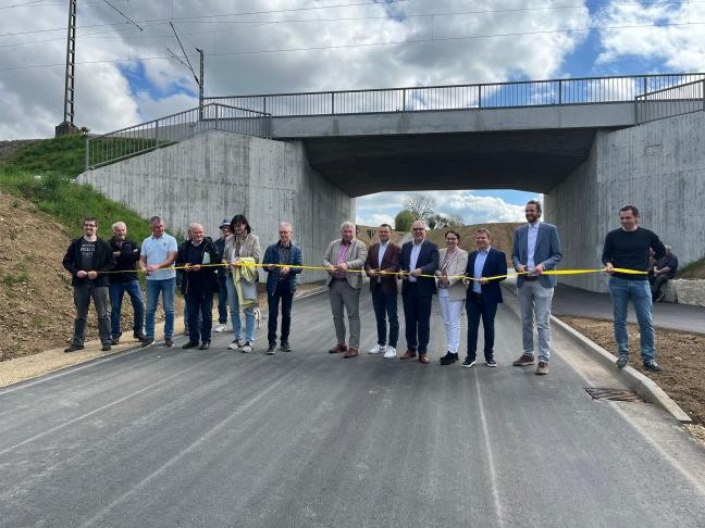 Teilnehmer an der Verkehrsfreigabe schneiden Band durch