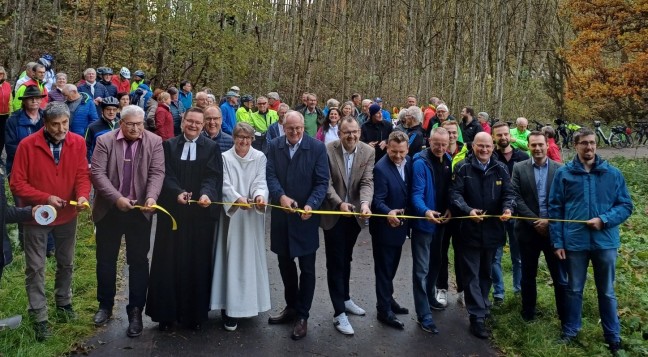 Durchschneiden des Bandes zur Eröffnung des Radwegs durch die Behördenvertreter